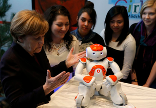 Illustration for article titled Why Is Angela Merkel Always Palling Around With Robots?